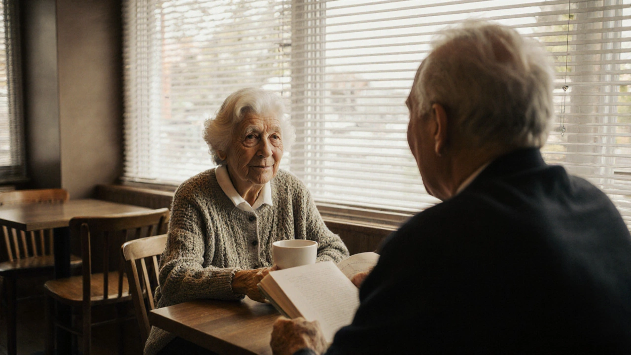 An older woman and man sit together in a quiet café, sharing coffee and a book in warm, natural light.
